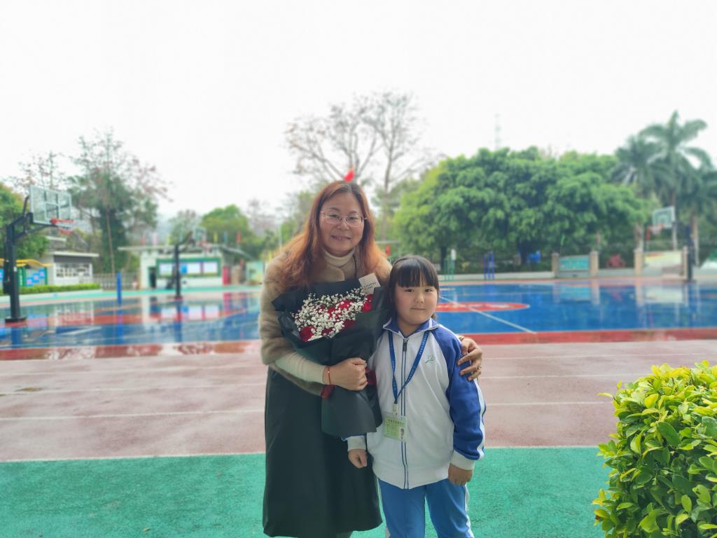 学生向女教师工送上鲜花