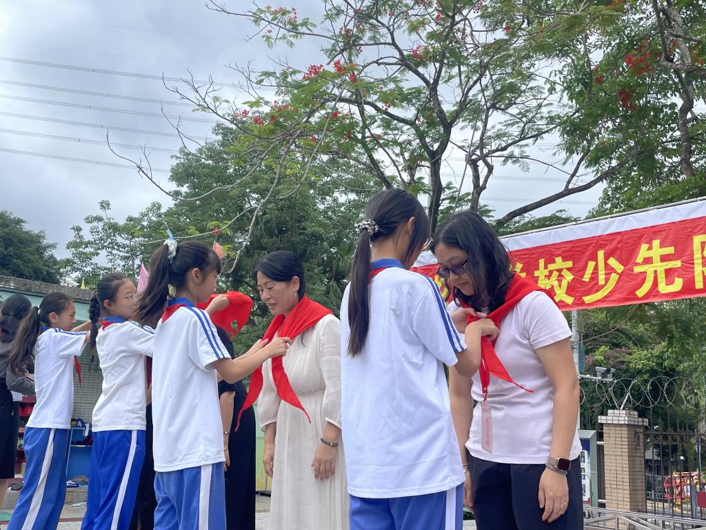 老队员向新队员佩戴红领巾