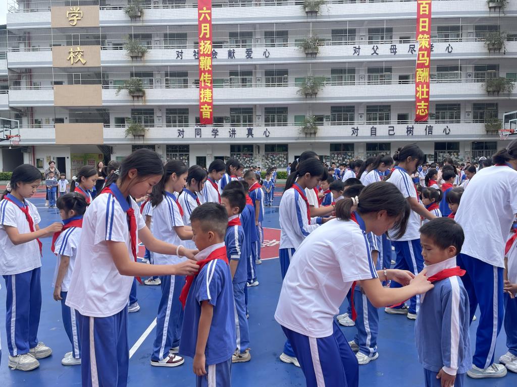 老队员向新队员佩戴红领巾