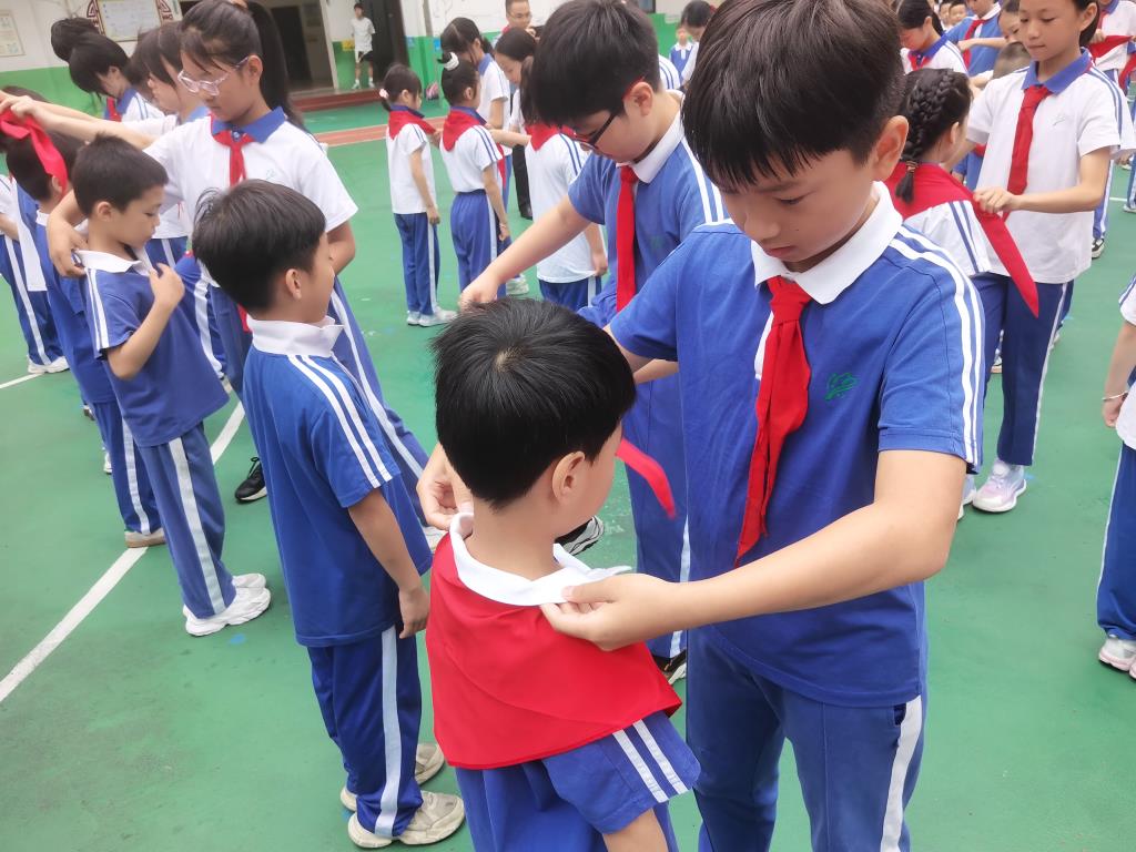 4.老队员给新队员佩戴红领巾