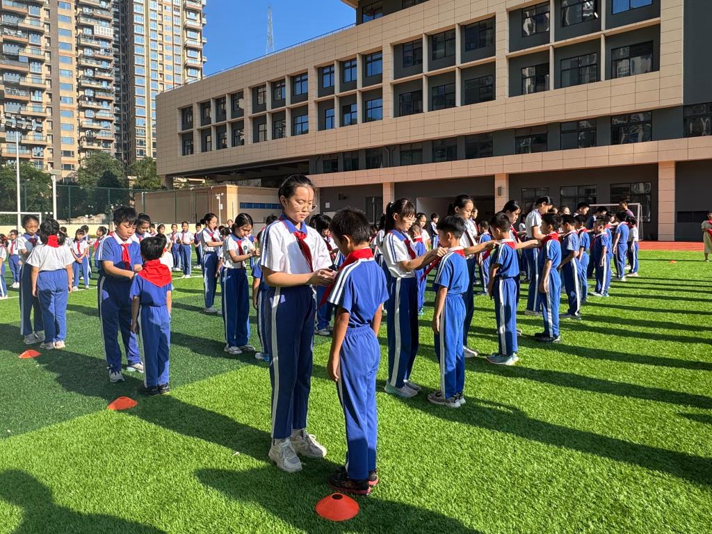 老队员为新队员佩戴红领巾