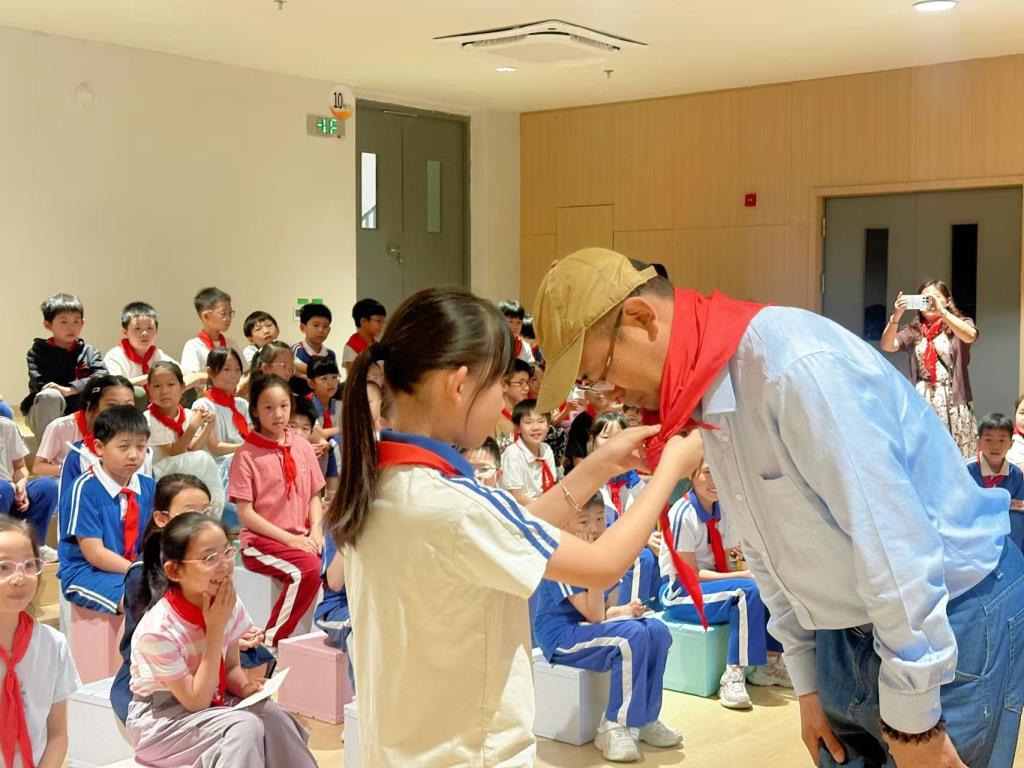 少先队员代表给徐建明叔叔佩戴红领巾
